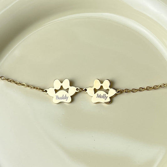 Gold pawprint charm bracelet engraved with pet names Buddy and Molly