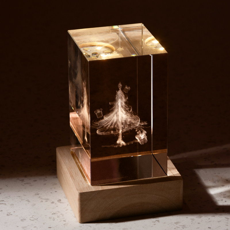 Engraved crystal block lit warmly on a wooden base