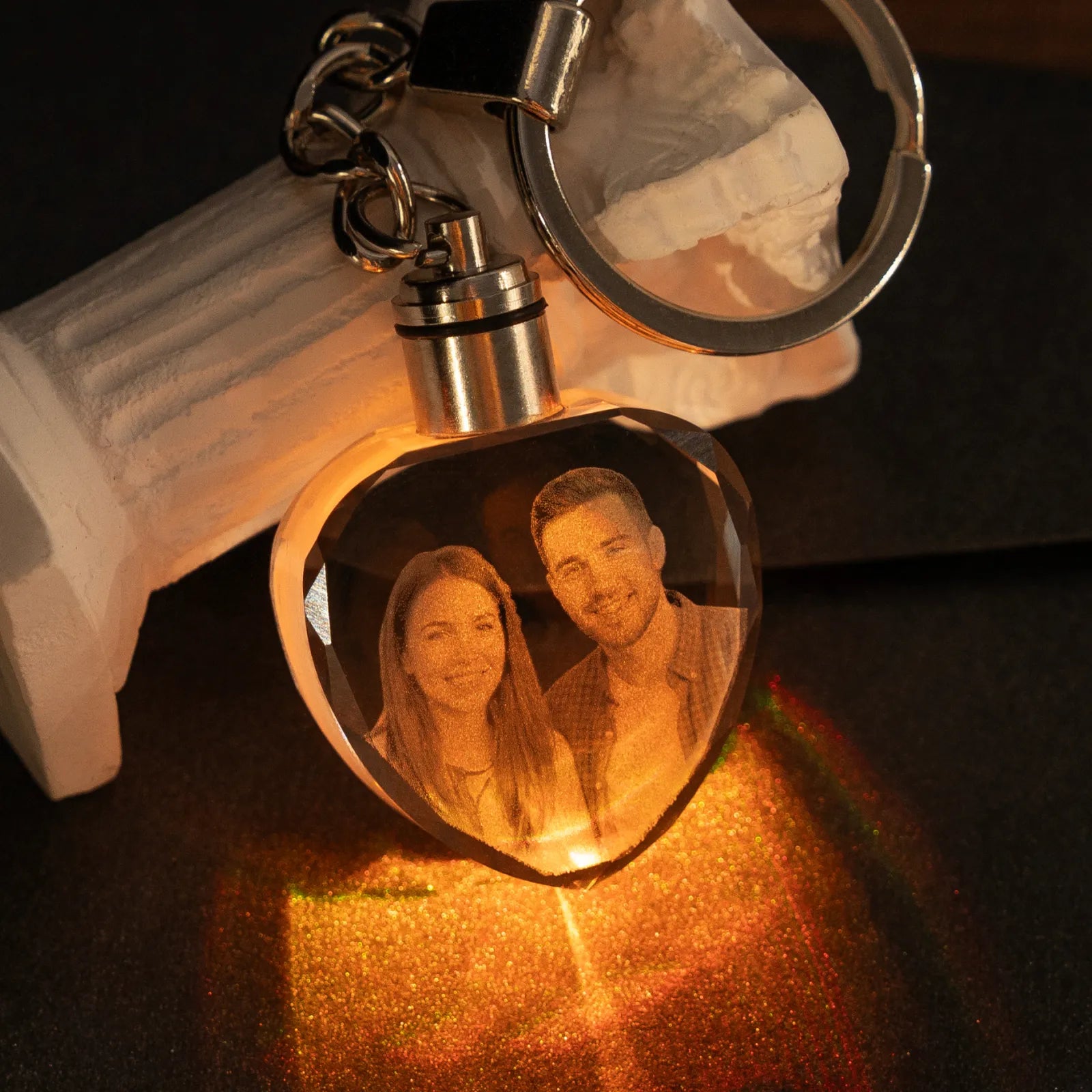 Heart crystal keychain engraved with a couple's photo, glowing warm